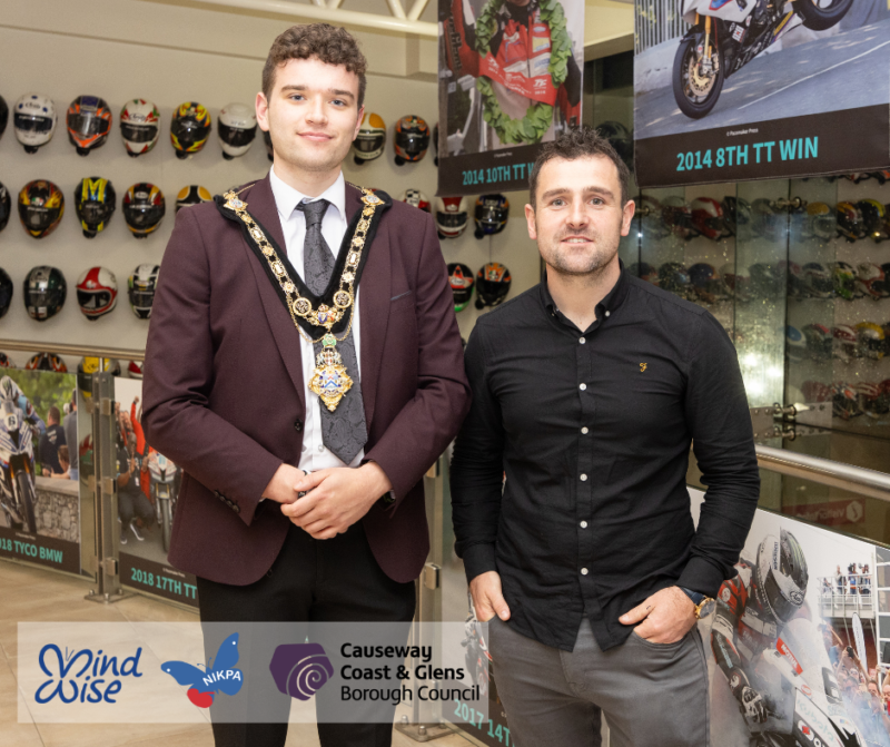 Ballymoney road racer Michael Dunlop pictured with the Mayor of Causeway Coast and Glens, Councillor Ciarán McQuillan, at his Homecoming event in October 2024. Image includes the logos for the Mayor’s charities MindWise and NIKPA. Also included is the Causeway Coast and Glens Borough Council logo.