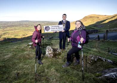 Mayor of Causeway Coast and Glens, Councillor Ciarán McQuillan pictured with Clare Quinn, Council Trade Engagement Officer and Mairéad Whall, Far and Wild at the launch of the 2025 Causeway Coast and Glens Walking Festival.