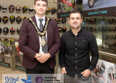 Ballymoney road racer Michael Dunlop pictured with the Mayor of Causeway Coast and Glens, Councillor Ciarán McQuillan, at his Homecoming event in October 2024. Image includes the logos for the Mayor’s charities MindWise and NIKPA. Also included is the Causeway Coast and Glens Borough Council logo.