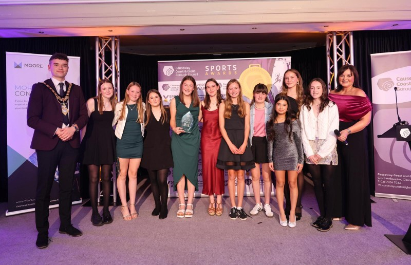 Mayor of Causeway Coast and Glens, Councillor Ciarán McQuillan presenting the ‘Merit’ Award on behalf of Causeway Active Kids, with Denise Watson and winners Coleraine Ladies Hockey Club U13’s.