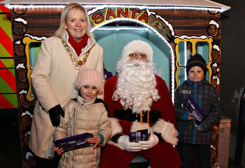 Mayor of Causeway Coast and Glens Borough Council, Councillor Michelle Knight-McQuillan at Santa's Grotto with Marika and Dawid who received a small gift from Santa..