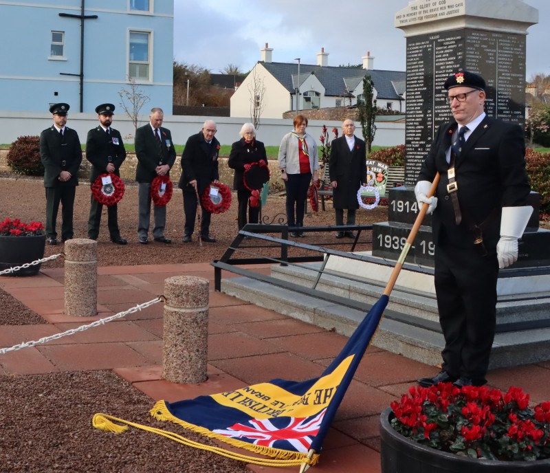 The annual Remembrance Day service in Ballycastle; the standard bearer is pictured with the standard lowered as a mark of respect.