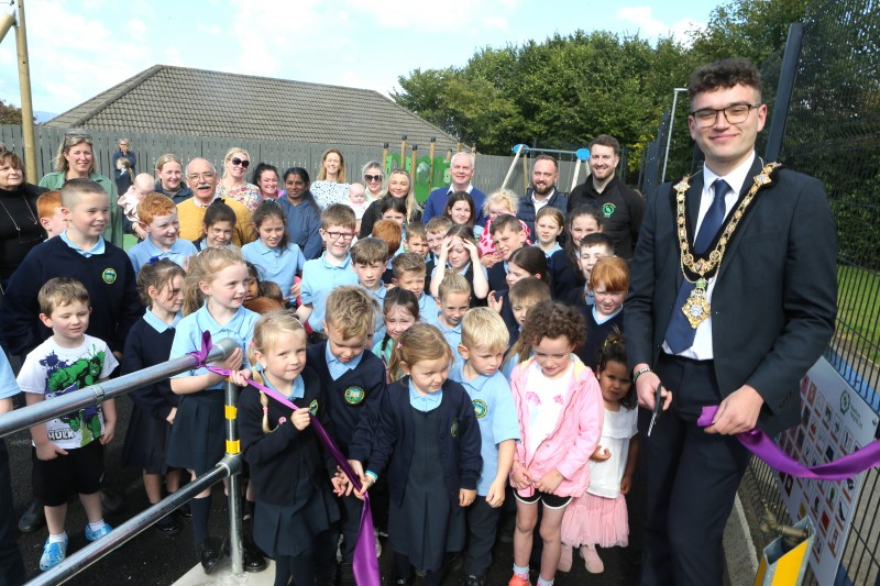 Mayor, Councillor Ciarán McQuillan cuts the ribbon to officially open the new state-of-the-art Greysteel Play Park.