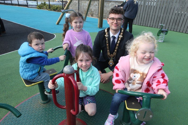 Mayor, Councillor Ciarán McQuillan pictured with some of the children enjoying the new play equipment.