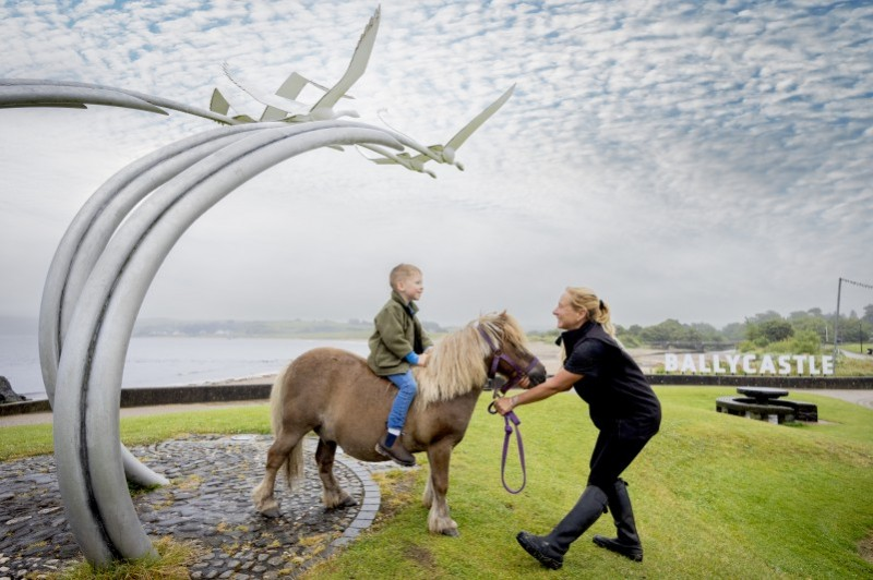 Melissa Lemon Chief Horse Steward and her grandson Caolan, with Topper at the Lir statue in Ballycastle Seafront.