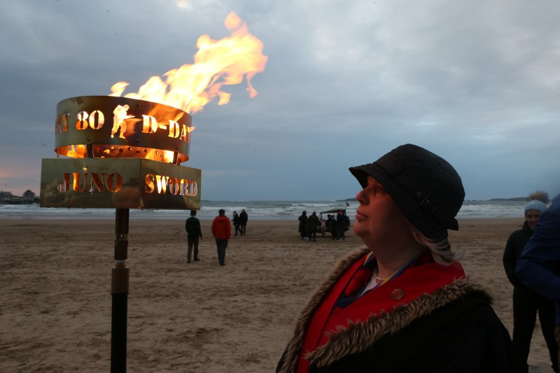 Alderman Michelle Knight-McQuillan, chair of the Garvagh branch of the Royal British Legion alongside the lit commemorative beacon at East Strand, Portrush to commemorate the 80th anniversary of D-Day.