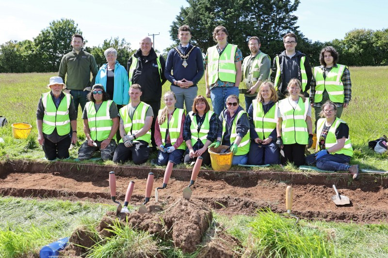 The Mayor of Causeway Coast and Glens, Councillor Ciarán McQuillan with staff from Council’s Museum Services, staff and students from Queen’s University Belfast Centre for Community Archaeology, and volunteers onsite at the Clare Rd excavation.