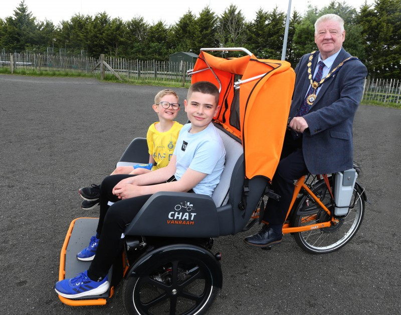The Mayor of Causeway Coast and Glens, Councillor Steven Callaghan, pictured alongside two children in one of Council’s inclusive bicycles.