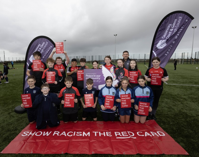 Pupils from Ballymoney High School & Our Lady of Lourdes School mark the “Show Racism the Red Card” campaign as part of the “Different Ball, Same Goal” project. Also included is Jonny McFadden, Sports Development Manager with CCGBC.