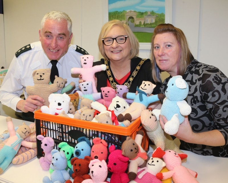 The Mayor of Causeway Coast and Glens Borough Council, Councillor Brenda Chivers pictured with Chief Inspector Ian Magee and Lucille Wright, Causeway Coast and Glens Borough Council with a selection of trauma teddies made by the Nimble Needles Knitting Group designed to bring comfort to children in distress.