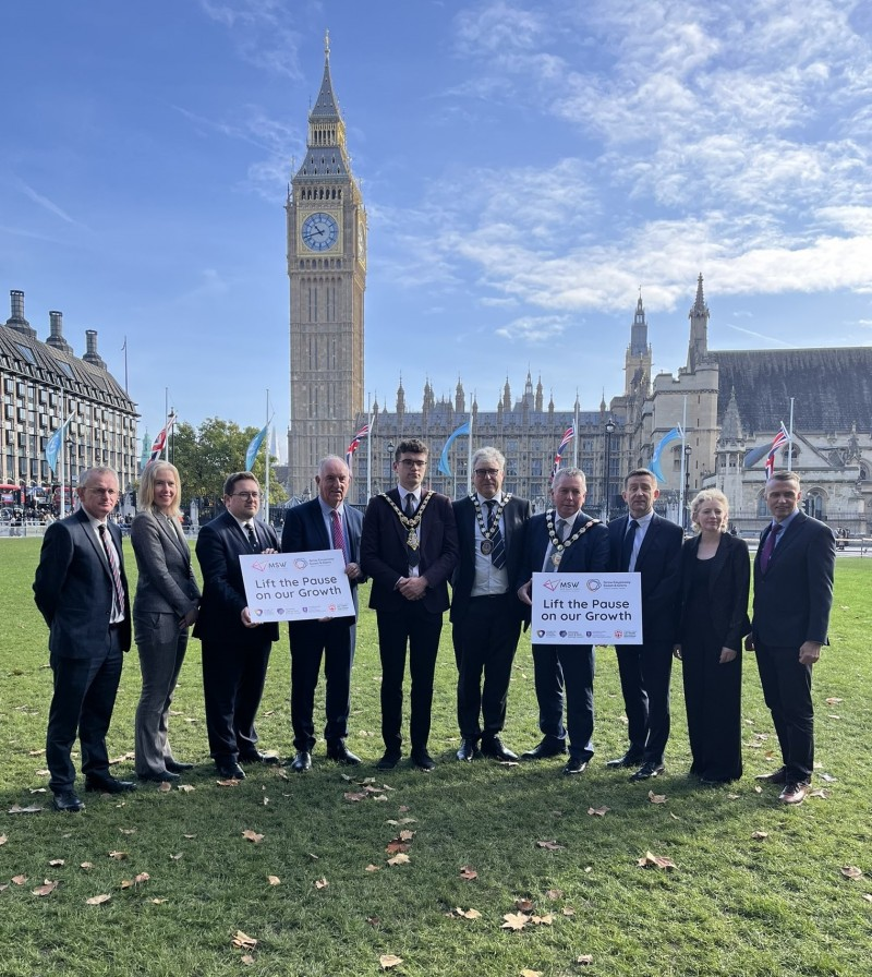 Wide shot of delegates arriving at Parliament Square Garden, with Westminster in the background.